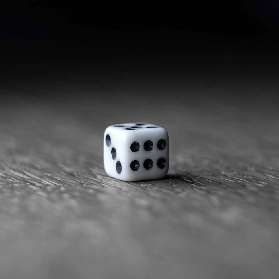 small white dice placed on wooden table